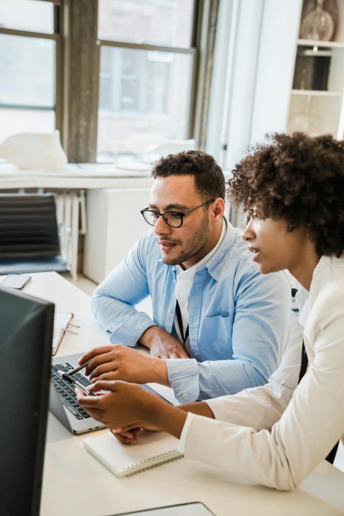 Two professionals collaborating on a project in a modern office environment.